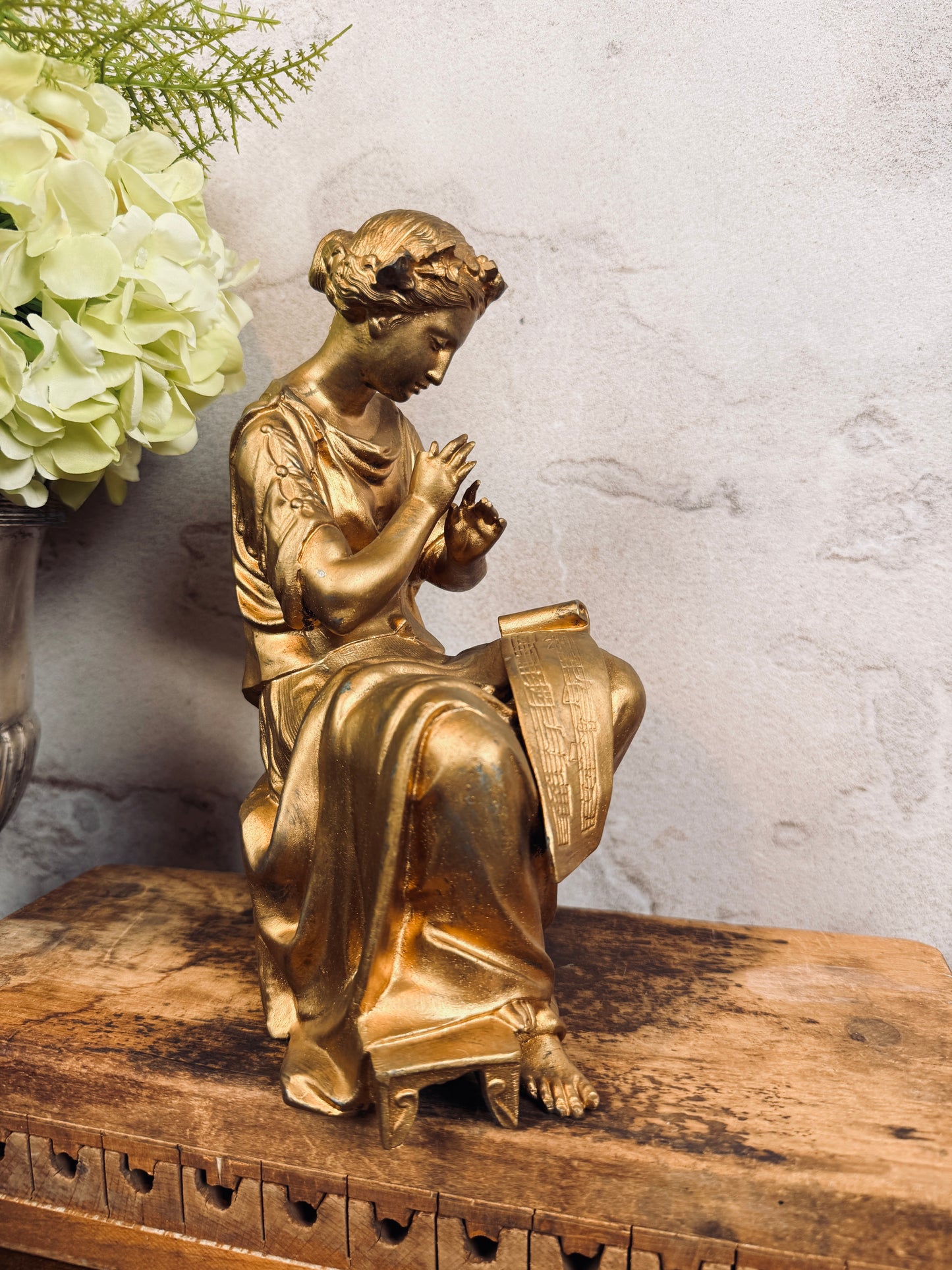 Spelter figural clock topper with laurel crown, sheet music & tambourine